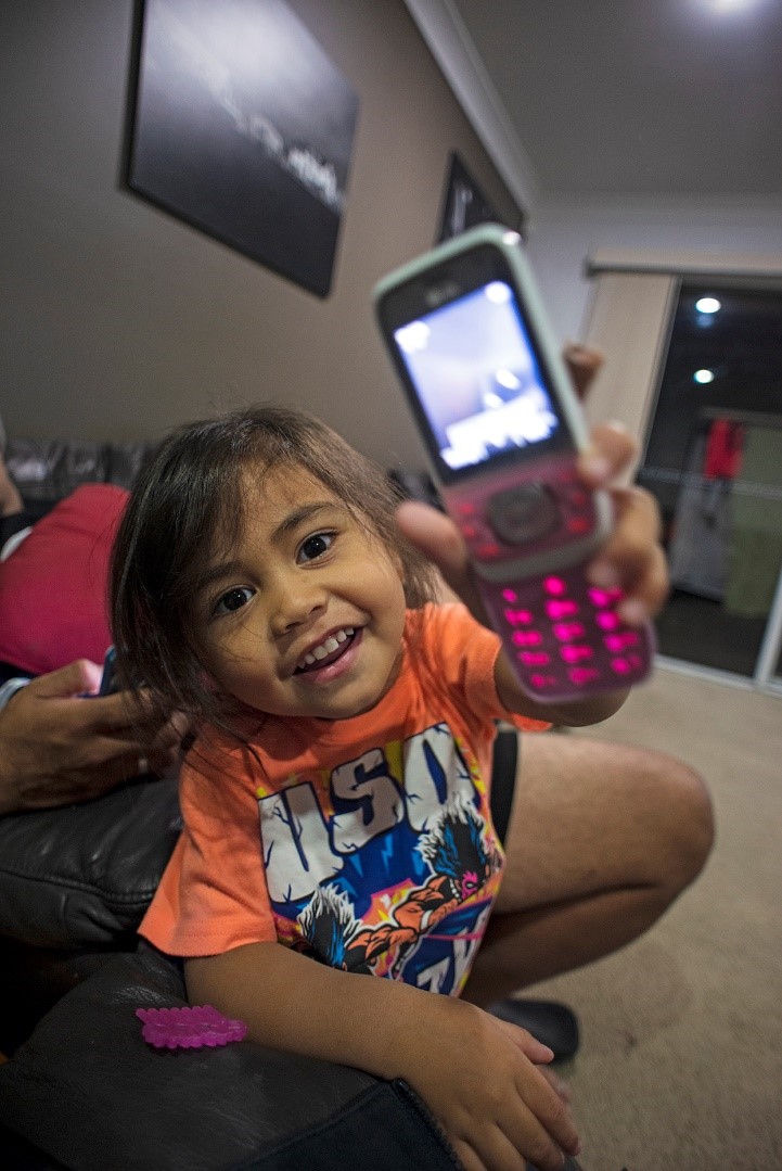 <p><em>Nassi offers me her phone.&nbsp;</em>Photo: Raymond Sagapolutele</p>