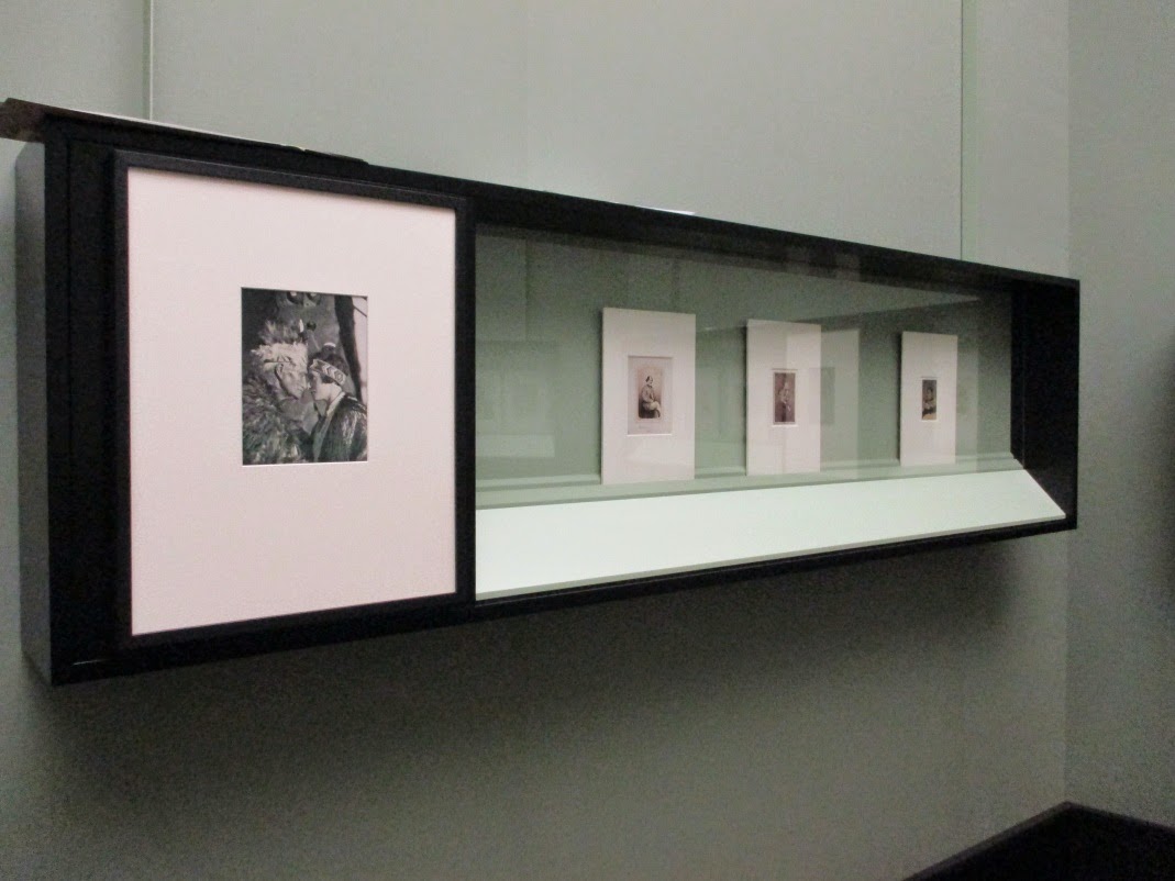 <p>The Technicians then secured the framed photographs to the vitrine panels and tested the positioning of the matted photographs within the vitrines, waiting for the Designer to finalise the layout.</p>
