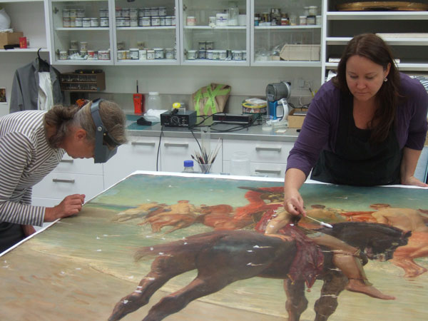 <p>Paintings Conservators Nel Rol and Ingrid Ford working on a treatment for the&nbsp;William Calderon painting&nbsp;<em>On the Sea-Beat Shore, Where Thracians Tame Wild Horses from Alexander Pope, Homer&#39;s Iliad</em>&nbsp;1905.</p>

