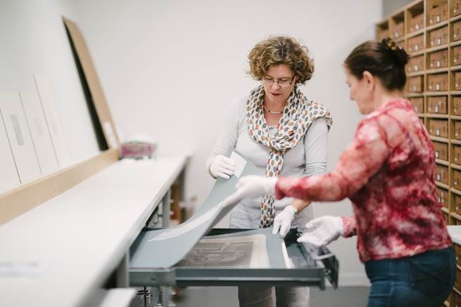 <p>Gallery conservators reviewing prints from the Auckland Art Gallery collection.&nbsp;</p>