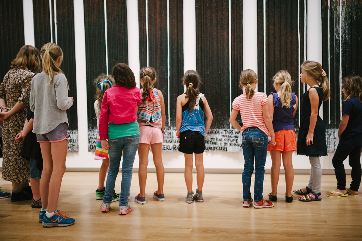 <p>Young visitors admiring a work by Ralph Hotere</p>
