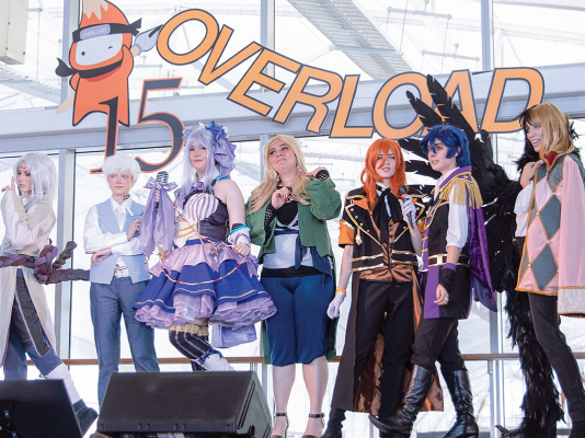 A group of people wearing cosplay costumes standing in a line at the Overload event