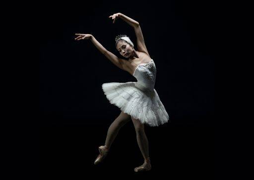 Solo ballerina in white ballet dress mid-pose