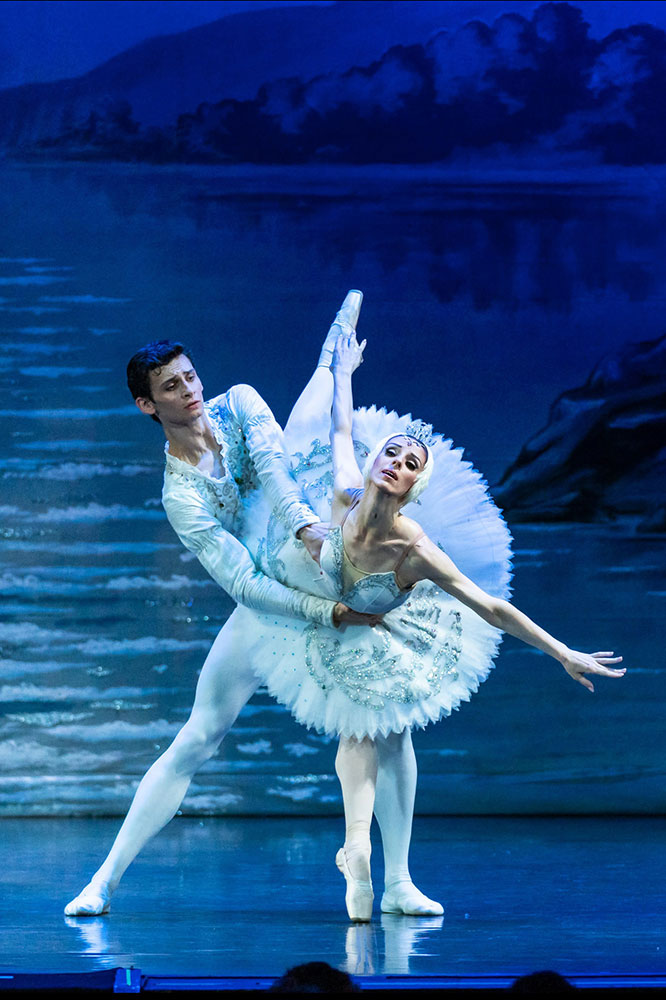 Ballerinas performing a pas de deux in Swan Lake on stage