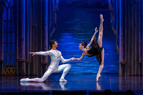 Ballerinas performing pas de deux in Swan Lake on stage