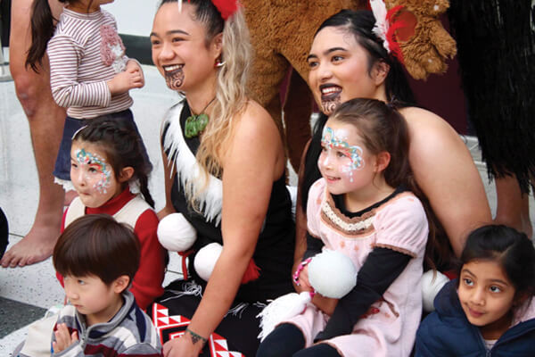 Children posing with Haka performers at The Haka experience event